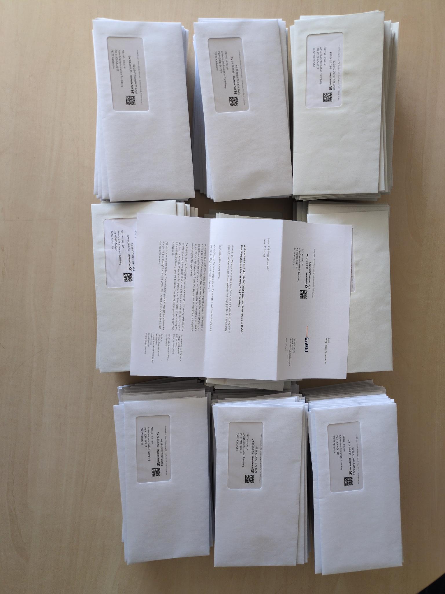 Briefumschläge, die Brief (scheinbar von der EnBW) beinhalten, darüber ein Brief beispielhaft aufgefaltet